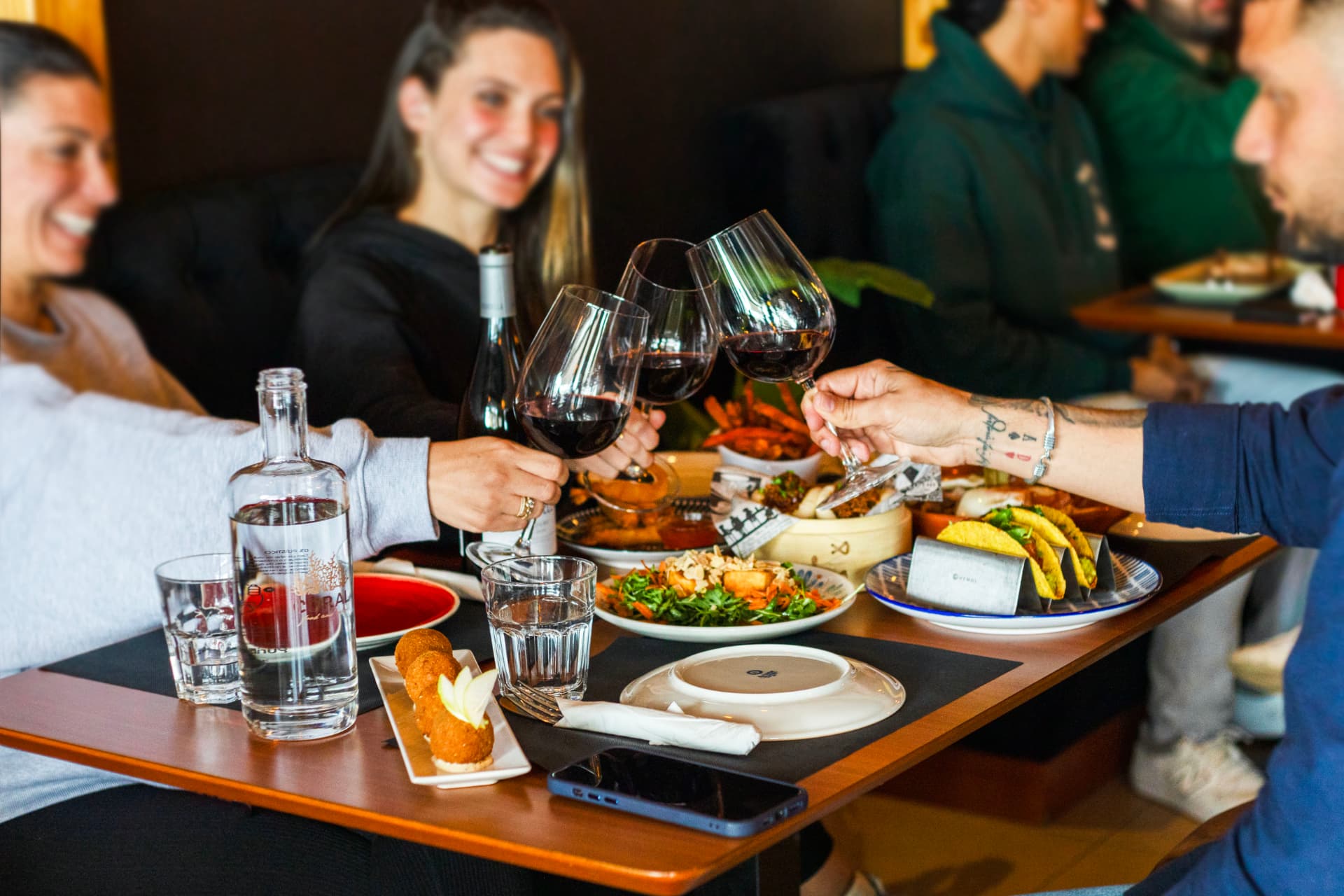 Amigos a brindar com vinho tinto no Coral Food & Wine em Quarteira
