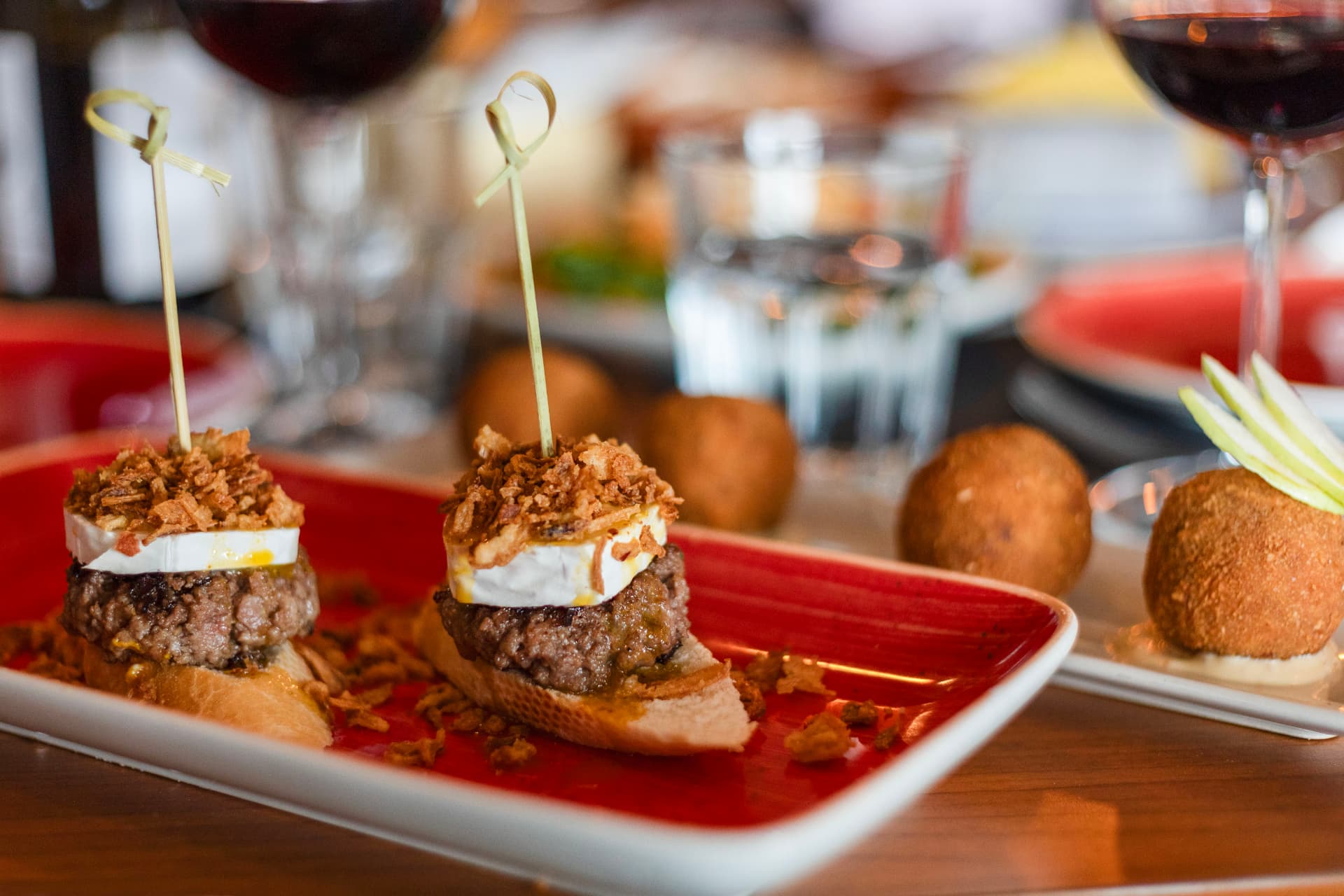 Mini hambúrgueres com queijo e cebola crocante no Coral Food & Wine